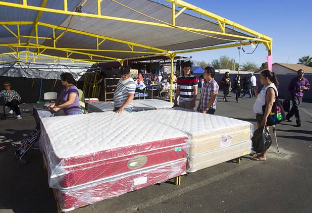 A family looks over mattresses at the Broadacres Marketplace & Events Center Sunday Nov. 3, 2013.