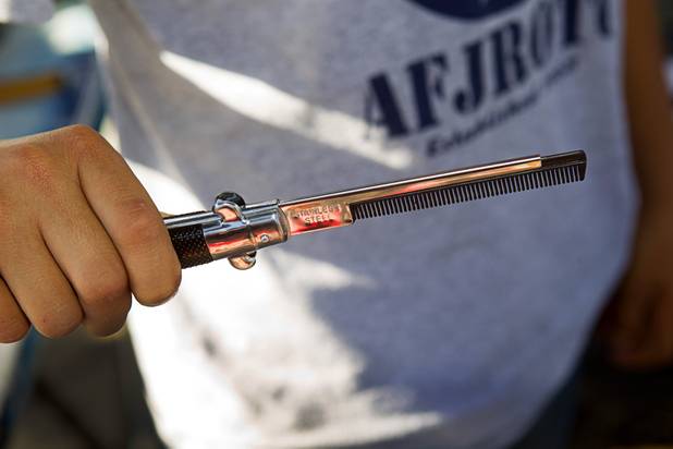Vendor Rodrigo Chavez displays a switchblade-style comb at the Broadacres Marketplace & Events Center Sunday Nov. 3, 2013.