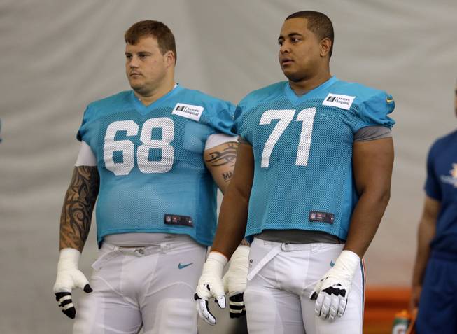 In this July 24, 2013, photo, Miami Dolphins guard Richie Incognito (68) and tackle Jonathan Martin (71) stand on the field during an NFL practice in Davie, Fla.