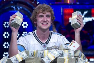 Ryan Riess, 23, a poker professional from East Lansing, Mich., poses with stacks of cash after winning the World Series of Poker $10,000 buy-in no-limit Texas Hold 'Em tournament at the Rio Tuesday, Nov. 5, 2013.
