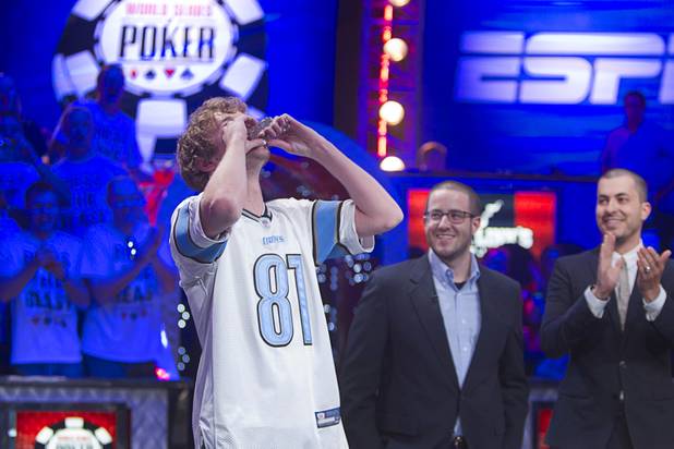 Ryan Riess, 23, a poker professional from East Lansing, Mich., kisses his championship bracelet after winning the World Series of Poker $10,000 buy-in no-limit Texas Hold 'Em tournament at the Rio Tuesday, Nov. 5, 2013. Greg Merson, 2102 WSOP main event winner, is at center.