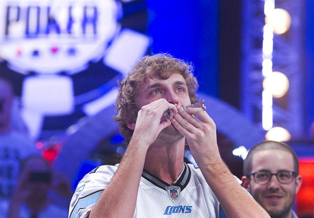 Ryan Riess, 23, a poker professional from East Lansing, Mich., kisses his championship bracelet after winning the World Series of Poker $10,000 buy-in no-limit Texas Hold 'Em tournament at the Rio Tuesday, Nov. 5, 2013. Greg Merson, 2102 WSOP main event winner, is at center.