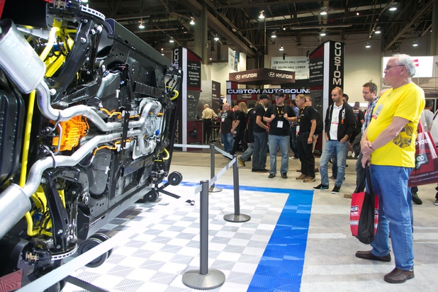 Exhibitors look at the undercarriage of the Chevrolet Camaro that has been lifted on to its side during the 2013 SEMA show at the Las Vegas Convention Center, Tuesday, Nov. 5, 2013.