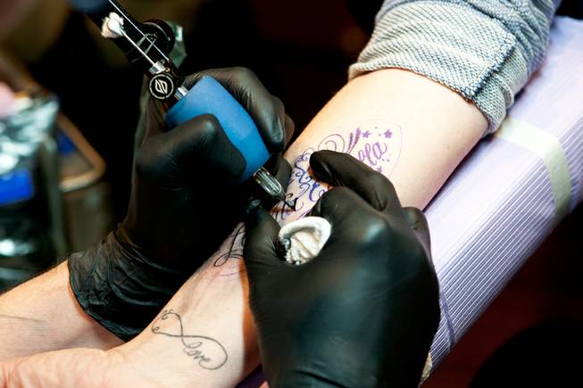 Joey Hamilton of Club Tattoo - Tattoo artist Joey Hamilton inks a quotation  on the forearm ... -