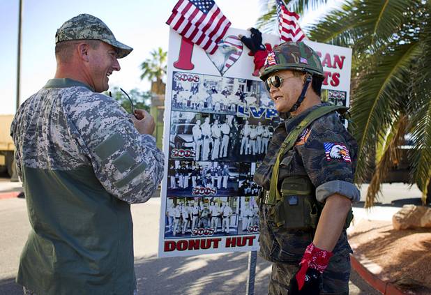 Veteran Warren Willis, left, talks with Sothy Seang, owner of the Donut Hut, before the Veterans Day parade in downtown Las Vegas Monday, Nov. 11, 2013. Seang fought with the Cambodian army against the Viet Cong during the Vietnam War.