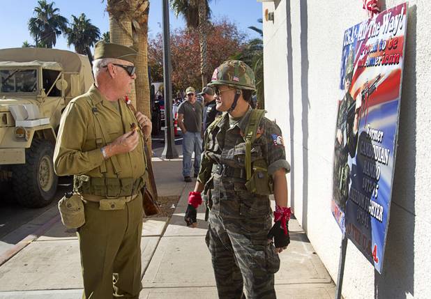 James McGeachy, left, of the Military Vehicle Preservation Association (MVPA), talks with Sothy Seang, owner of the Donut Hut, marches in the Veterans Day parade in downtown Las Vegas Monday, Nov. 11, 2013. McGreachy said Seang used to march by himself but after becoming friends, Seang now marches with the MPVA entries. Seang fought with the Cambodian army against the Viet Cong during the Vietnam War.