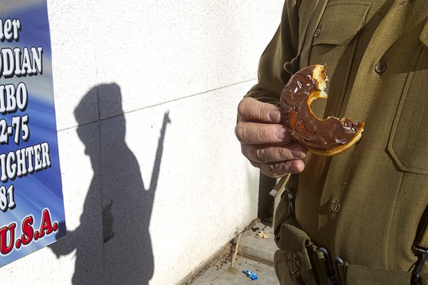 James McGeachy of the Military Vehicle Preservation Association (MVPA), eats a Donut Hut doughnut before the Veterans Day parade in downtown Las Vegas Monday, Nov. 11, 2013. Sothy Seang, owner of the Donut Hut, used to march by himself but after becoming friends, Seang now marches with the MPVA entries, McGreachy said. Seang fought with the Cambodian army against the Viet Cong during the Vietnam War.