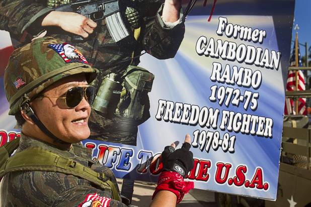 Sothy Seang, owner of the Donut Hut, explains his sign during an interview before marching in the Veterans Day parade in downtown Las Vegas Monday, Nov. 11, 2013. Seang fought with the Cambodian army against the Viet Cong during the Vietnam War.