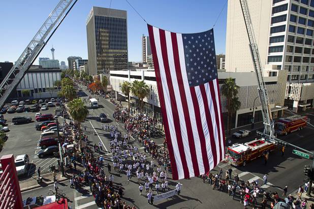 A Chase Bank entry passes under an American flag during the annual Veterans Day parade in downtown Las Vegas Monday, Nov. 11, 2013.