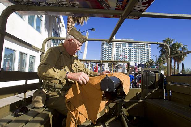 James McGreachy with the Military Vehicle Preservation Association unwraps a1917 Browning .30 caliber machine gun before the start of the annual Veterans Day parade in downtown Las Vegas Monday, Nov. 11, 2013. "It makes people nervous it I drive around with the gun unwrapped," he said.