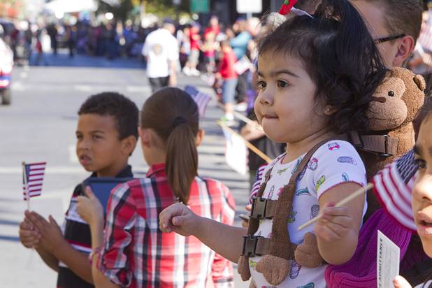 Ava Ramirez, 2, waves a flag as she watches the annual Veterans Day parade in downtown Las Vegas Monday, Nov. 11, 2013.