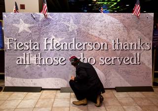Greg Bashaw, as commander of the Henderson VFW Post 3848, joins others at the Fiesta Casino to sign a banner for Veteran's Day and enjoy a free buffet for those who served in the military on Monday, Nov. 11, 2013.