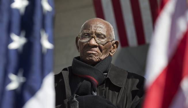 Richard Overton the oldest living WWII veteran, listens during a Veterans Day ceremony attended by President Barack Obama on Monday, Nov. 11, 2013, at Arlington National Cemetery.
