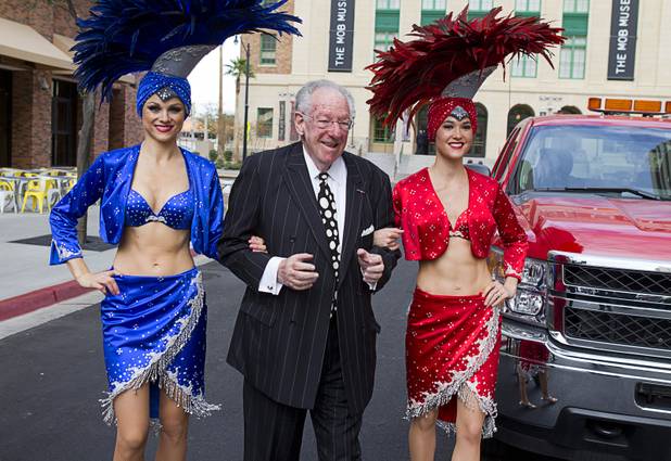Former Las Vegas Mayor Oscar Goodman arrives with showgirls during an official opening ceremony for the Downtown Grand in downtown Las Vegas Tuesday, Nov. 12, 2013.