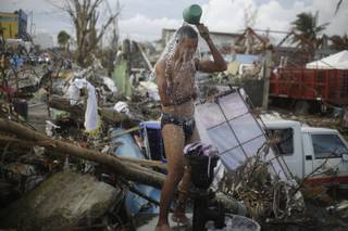 A man takes a shower amid rubble in an area badly affected by Typhoon Hayan in Tacloban, central Philippines, Wednesday, Nov. 13, 2013. 