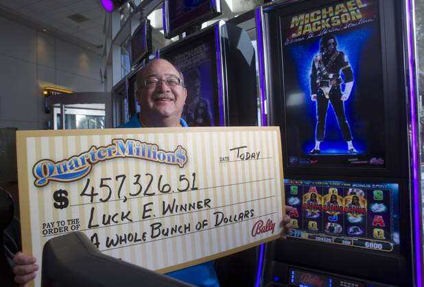 E.J. Coyle, a project manager at Bally Technologies, poses with an oversized mock check at the company lobby Thursday, Nov. 14, 2013. Coyle is a member of the Jackpot Response Team. A member is always on call in the event that a gambler hits a progressive jackpot on a Bally Technologies slot machine.
