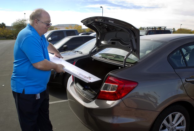 E.J. Coyle, a project manager at Bally Technologies, places oversized checks into the truck of his car at the company Thursday, Nov. 14, 2013. Coyle is a member of the Jackpot Response Team. A member is always on call in the event that a gambler hits a progressive jackpot on a Bally Technologies slot machine.