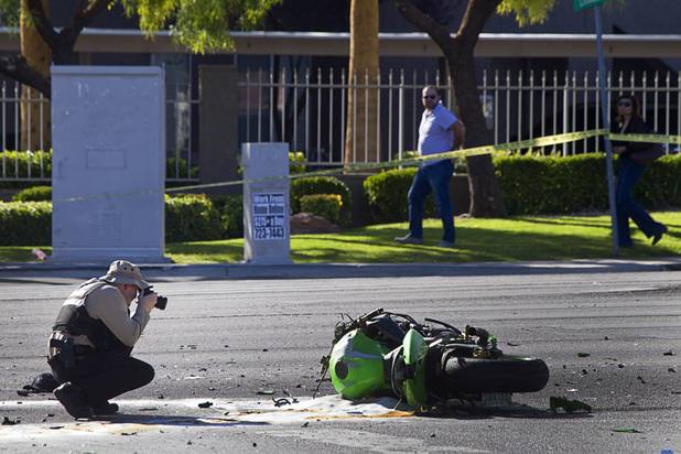 A Metro Police crime scene analyst takes a photos at a fatal motorcycle accident at the intersection of Flamingo and Lindell roads Thursday, Nov. 14, 2013. 
