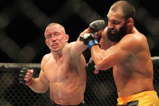 Georges St. Pierre hits Johny Hendricks with a left during their title fight at UFC 167 Saturday, Nov. 16, 2013 at the MGM Grand Garden Arena. St. Pierre won with a controversial split decision.