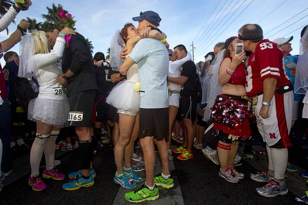 Cheryl Coelho and Greg Pannone, center, kiss after getting married in a mass service during the 5th annual Rock 'n' Roll Las Vegas Marathon Sunday, Nov. 17, 2013.