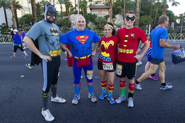 Runners dressed as super heroes, from left, Jacob Daponte, Ed Travers, Nicole Silvia and Zach Lyons, all of Bristol, R.I. pose before the 5th annual Rock 'n' Roll Las Vegas Marathon Sunday, Nov. 17, 2013.