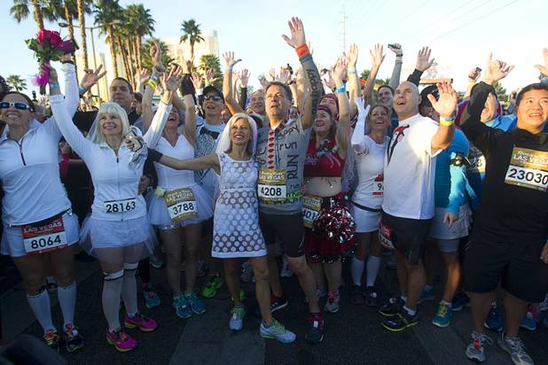 Couples, including Carol and Paul Cote, center, of New York City pose for a photo during the 5th annual Rock 'n' Roll Las Vegas Marathon Sunday, Nov. 17, 2013. The Cotes were among the couple who married at the marathon.