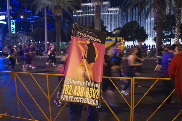 A man wearing an mobile advertising sign encourages runners during the 5th annual Rock 'n' Roll Las Vegas Marathon Sunday, Nov. 17, 2013.