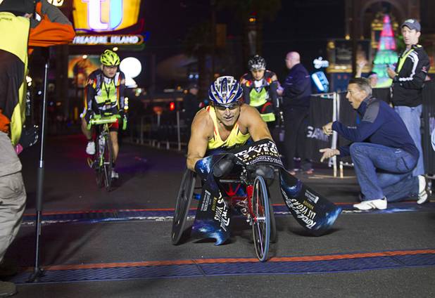 Wheelchair competitor Grant Berthiaume of Tucson, Ariz. crosses the finish line during the 5th annual Rock 'n' Roll Las Vegas Marathon Sunday, Nov. 17, 2013. Berthiaume won the wheelchair marathon in 2:08:38.