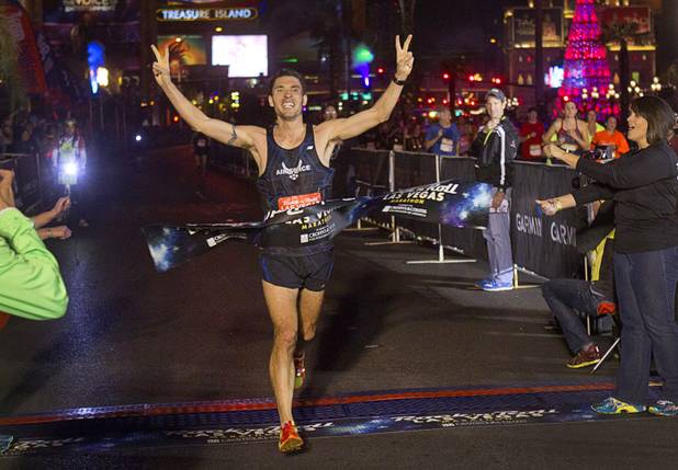 Jason Brosseau of Colorado Springs, Colo. crosses the finish line after finishing in first place during the 5th annual Rock 'n' Roll Las Vegas Marathon Sunday, Nov. 17, 2013. Brosseau finished in 2 hours, 35 minutes and 26 seconds.