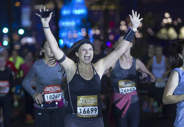 A runner celebrates as she crosses the finish line during the 5th annual Rock 'n' Roll Las Vegas Half Marathon Sunday, Nov. 17, 2013.