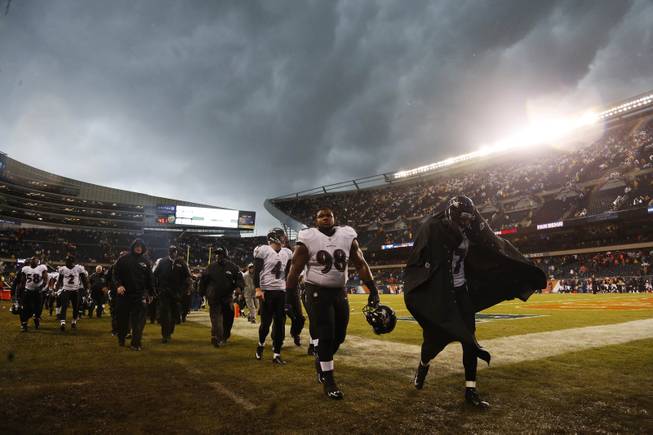 Baltimore Ravens players leave the field as play was suspended for a severe thunderstorm blowing through Soldier Field during the first half of an NFL football game against the Chicago Bears, Sunday, Nov. 17, 2013, in Chicago. 