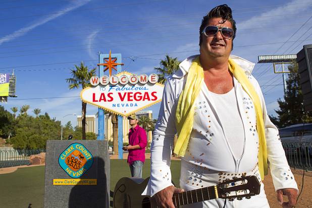Elvis Presley impersonator Mark Rumpler watches as journalists set up for a groundbreaking ceremony at the "Welcome to Fabulous Las Vegas" sign on Las Vegas Boulevard South Monday, Nov. 18, 2013. The groundbreaking was for a photovoltaic solar installation which will power the sign. The project is funded by donations from the Consumer Electronics Association, NV Energy, the Las Vegas Centennial Commission and Bombard Renewable Energy.