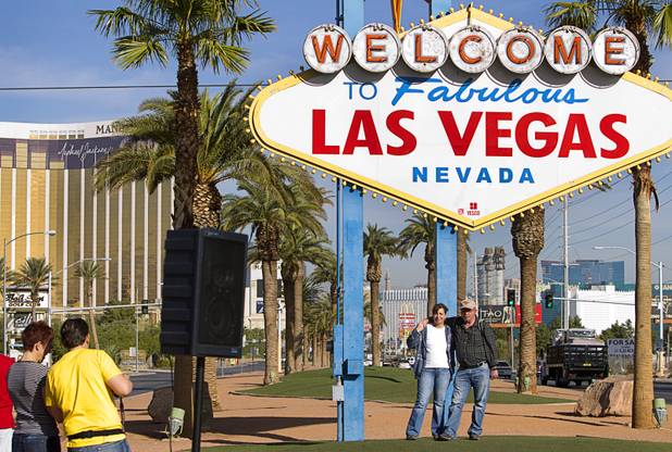 Herman Golbach and his wife Dunja of Germany have their photo taken during a groundbreaking ceremony at the "Welcome to Fabulous Las Vegas" sign on Las Vegas Boulevard South Monday, Nov. 18, 2013. The groundbreaking was for a photovoltaic solar installation which will power the sign.