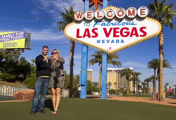 Mark Morgan and Silvana Dasilva take a self-portrait with their phone during a groundbreaking ceremony at the "Welcome to Fabulous Las Vegas" sign on Las Vegas Boulevard South Monday, Nov. 18, 2013. The groundbreaking was for a photovoltaic solar installation which will power the sign. The project is funded by donations from the Consumer Electronics Association, NV Energy, the Las Vegas Centennial Commission and Bombard Renewable Energy.