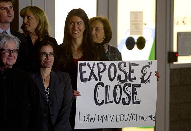 Katelyn Cantu holds a sign as protesters pose for a photo outside the Henderson Detention Center Tuesday, Nov. 19, 2013. The protesters are concerned about a UNLV law clinic report that raises questions about the conditions for immigrants at the detention center.
