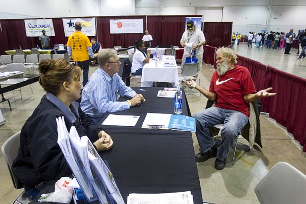 Duwayne Newton, 61, right, talks with Vons human resources representatives Laurel Cruz-Esau and Mike McHugh during the Fall 2013 Southern Nevada Project Homeless Connect at Cashman Field Center Tuesday, Nov. 19, 2013. The annual event brings together a variety of social and legal services to help homeless and low-income people.