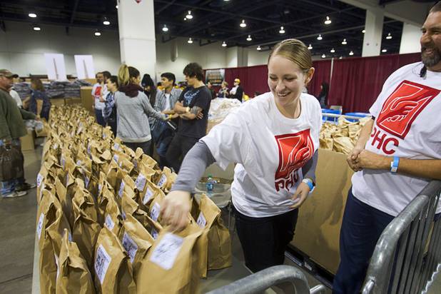 Volunteer Shayla Thayer, a leasing agent with 707 Property Management, puts out sack lunches during the Fall 2013 Southern Nevada Project Homeless Connect at Cashman Field Center Tuesday, Nov. 19, 2013. The annual event brings together a variety of social and legal services to help homeless and low-income people.
