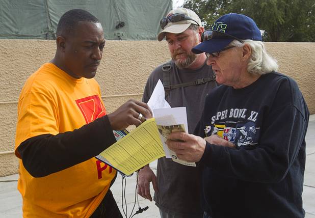 Tyrone Thompson, left, Regional Initiatives Coordinator for the Southern Nevada Regional Planning Coalition, helps resolve an issue for Dewitt Weaver, right, during the Fall 2013 Southern Nevada Project Homeless Connect at Cashman Field Center Tuesday, Nov. 19, 2013. The annual event brings together a variety of social and legal services to help homeless and low-income people.
