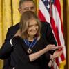 Women’s rights activist Gloria Steinem gestures as President Barack Obama awards her with the Presidential Medal of Freedom on Wednesday, Nov. 20, 2013, during a ceremony in the East Room of The White House in Washington, D.C. 