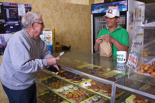 Bill Schoessler, left, buys doughnuts from Sothy Seang, 57, at the Donut Hut, 3242 E Desert Inn Rd., Sunday, Nov. 24, 2013. Seang fought with the Cambodian army against the Viet Cong during the Vietnam War. He later immigrated to the U.S. He has owned the Donut Hut in Las Vegas for 22 years.