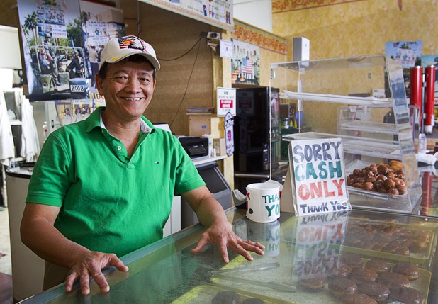Sothy Seang, 57, is shown at the Donut Hut, 3242 E. Desert Inn Road, on Sunday, Nov. 24, 2013. The Donut Hut doesn't take debit or credit cards, and Seang is not modernizing. "People go to the ATM and get cash because they need my doughnuts," he said.