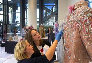 Shannon Nutt, left assistant curator, and curator Dierdra Clemente look over a Liberace costume prior to the opening of 