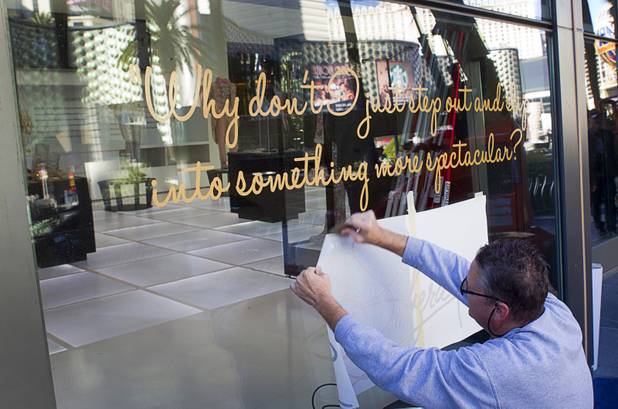 Scott Springmeyer, a graphics installer with Insane Installations, applies lettering to a window before the opening of "Too Much of a Good Thing Is Wonderful: Liberace and the Art of Costume" in the Cosmopolitan Monday, Nov. 25, 2013. The exhibit opened Monday and will run through Jan.1, 2014. Admission is free but any donations will benefit the Liberace Foundations scholarship fund.