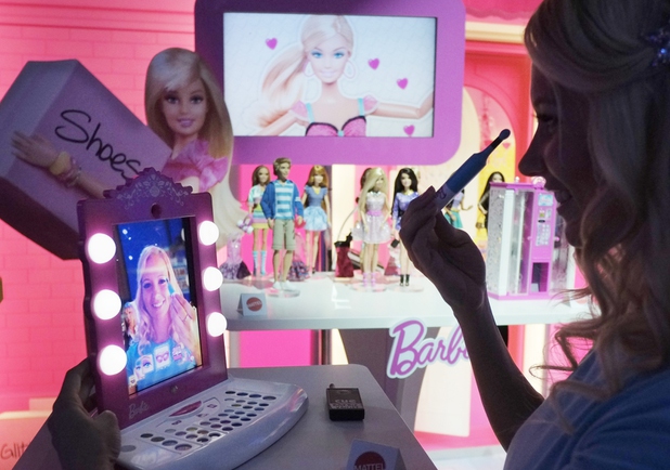 Mattel's Barbie Digital Makeover Mirror is demonstrated at the American International Toy Fair, Tuesday, Feb. 12, 2013 in New York.  An iPad uses facial tracking technology to transform into a digital mirror that invites girls to select their own makeup. 