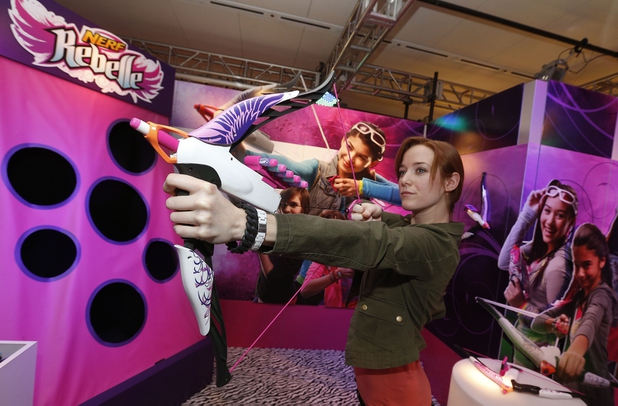 Demonstrator Kaitlin Large practices with the NERF REBELLE HEARTBREAKER Bow in Hasbro’s showroom at the American International Toy Fair, Saturday, Feb. 9, 2013, in New York.  