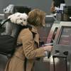 Corie Geller checks in for her flight to Kansas City with her dog Rocky in tow, at O'Hare International Airport in Chicago, Nov. 23, 2005.