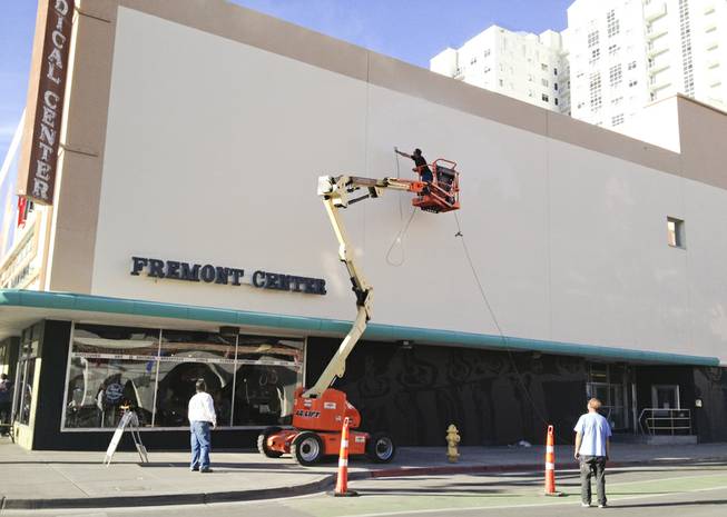 A fresh coat of paint is added to the Emergency Arts' building wall, which used to display a Life is Beautiful Festival mural Tuesday, Nov. 26, 2013.