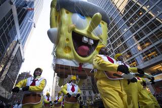 A giant Spongebob Squarepants balloon is marched down 6th Avenue during the 87th Annual Macy's Thanksgiving Day Parade, Thursday, Nov. 28, 2013, in New York. After fears the balloons could be grounded if sustained winds exceeded 23 mph, Snoopy, Spider-Man and the rest of the iconic balloons received the all-clear from the New York Police Department to fly between Manhattan skyscrapers on Thursday.