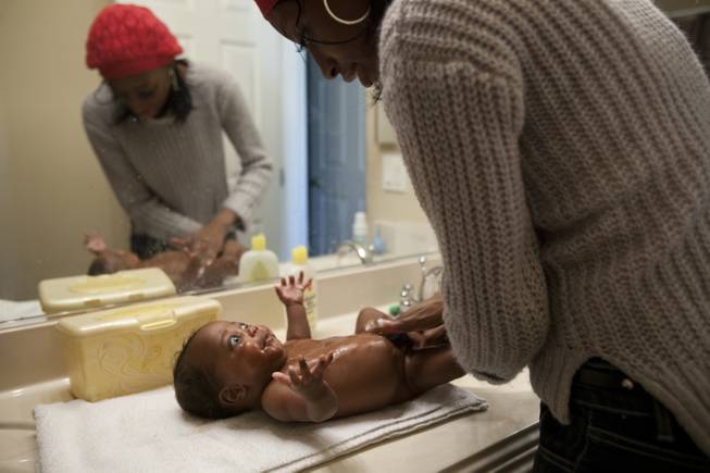 Evonne Derrico, mother of quintuplets, bathes one of her newborns prior to the quint's eye doctor visit Monday, Dec. 2, 2013.
