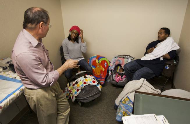 An eye doctor talks with Evonne and Deon Derrico about the quintuplet's progress during a visit on Monday, Dec. 2, 2013.